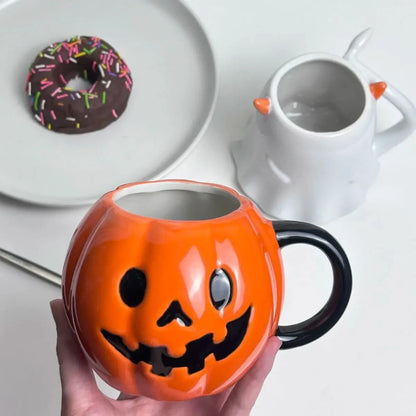 Person holding a Halloween Mug Pumpkin with a plate and cup in the background